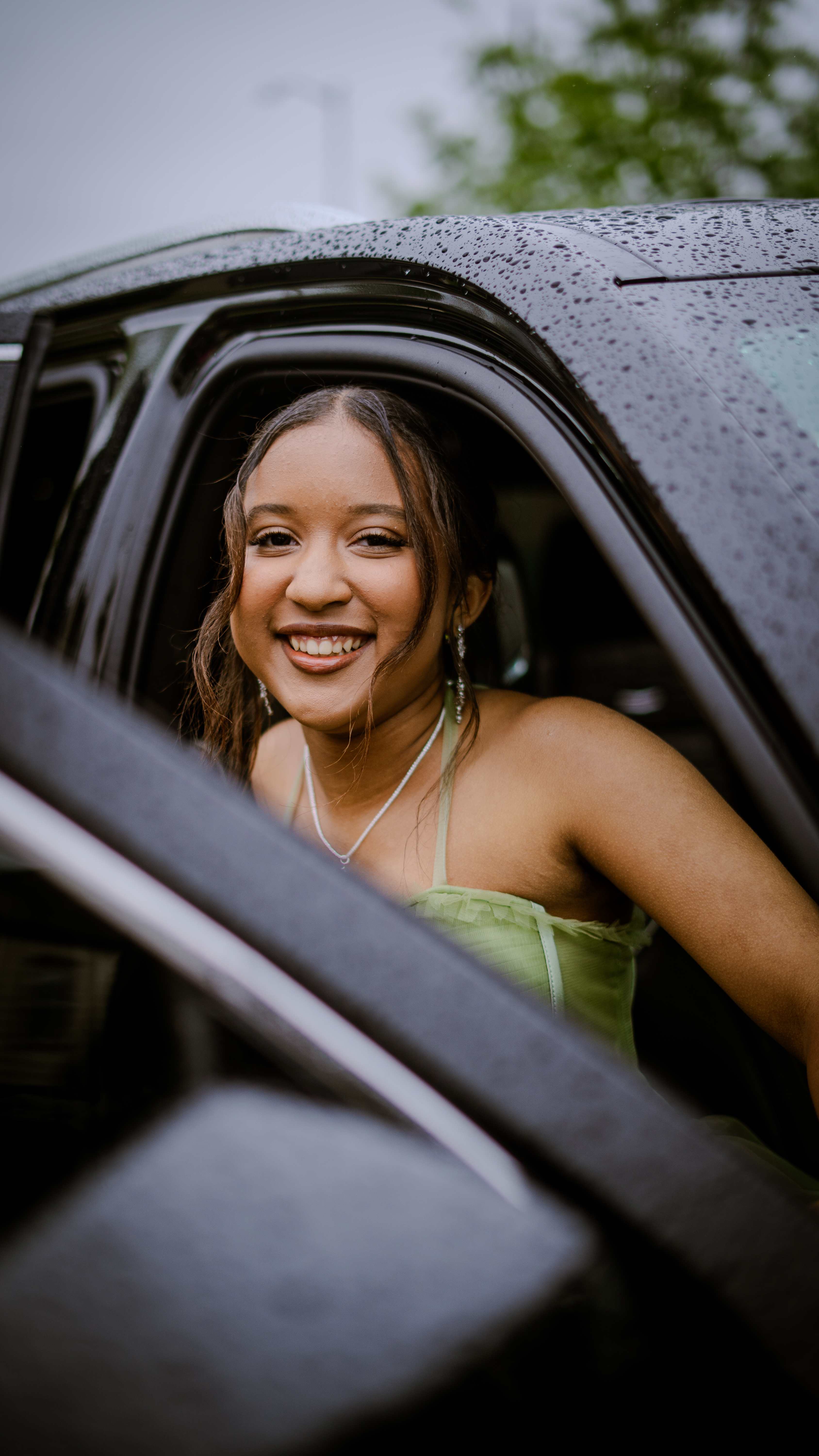 Graduate smiling from car window