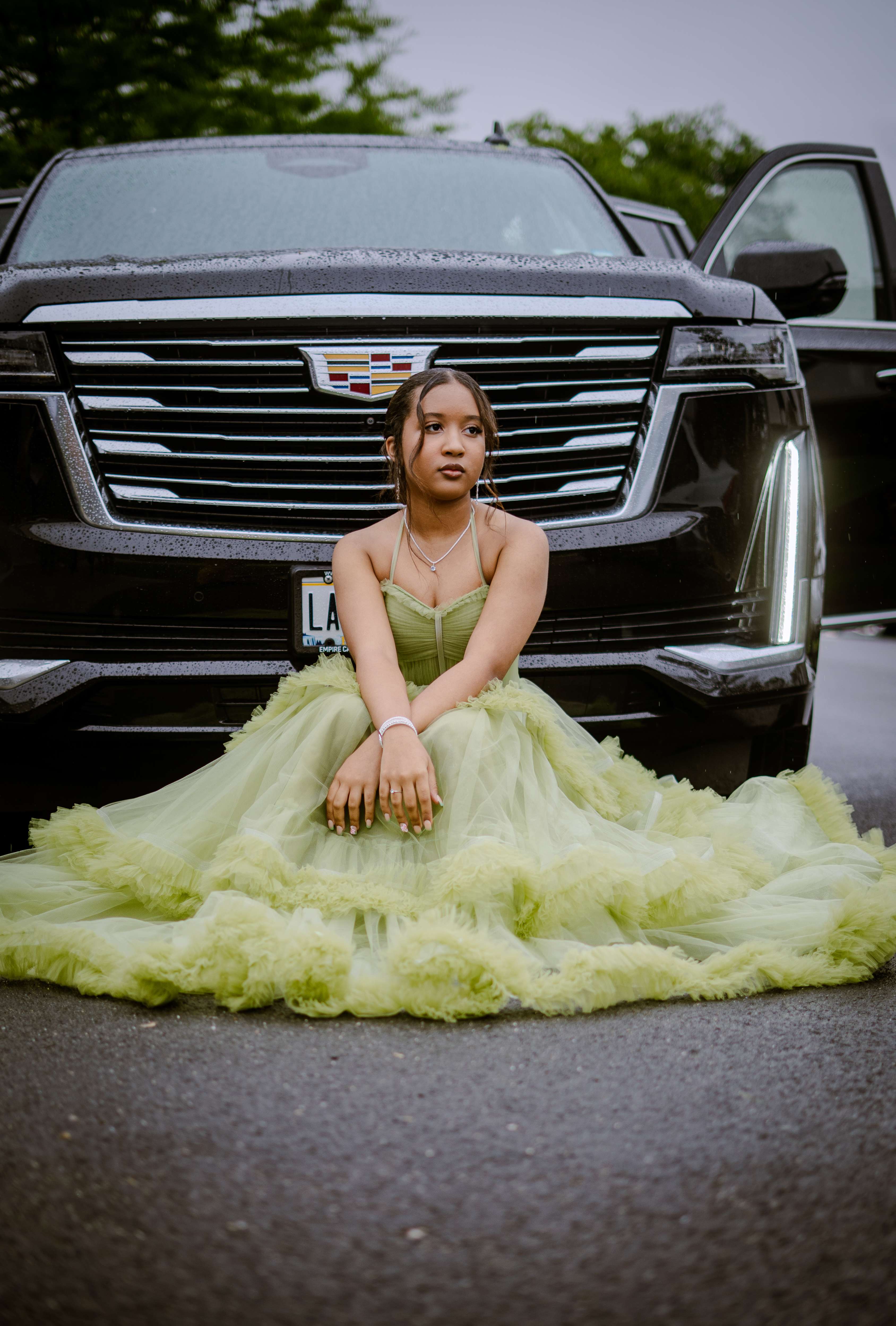 Graduate in mint green dress sitting on ground